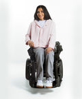 Person using a power wheelchair on a white background