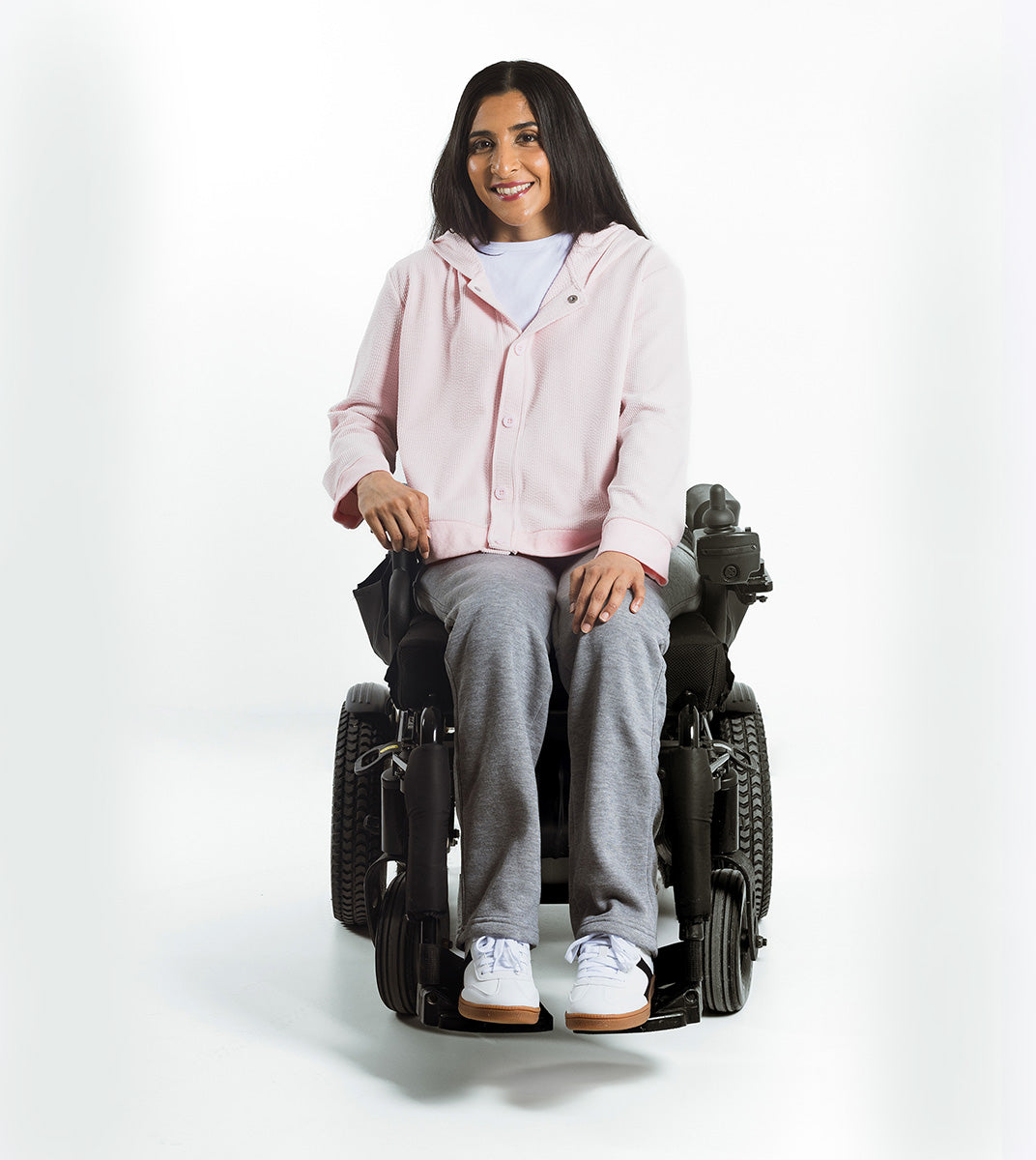 Person using a power wheelchair on a white background